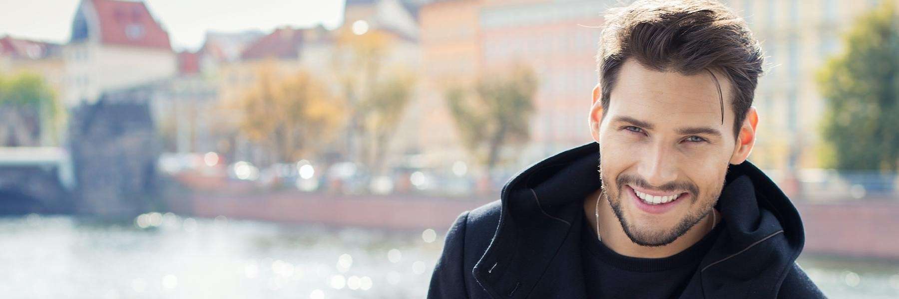 A smiling man in front of a river