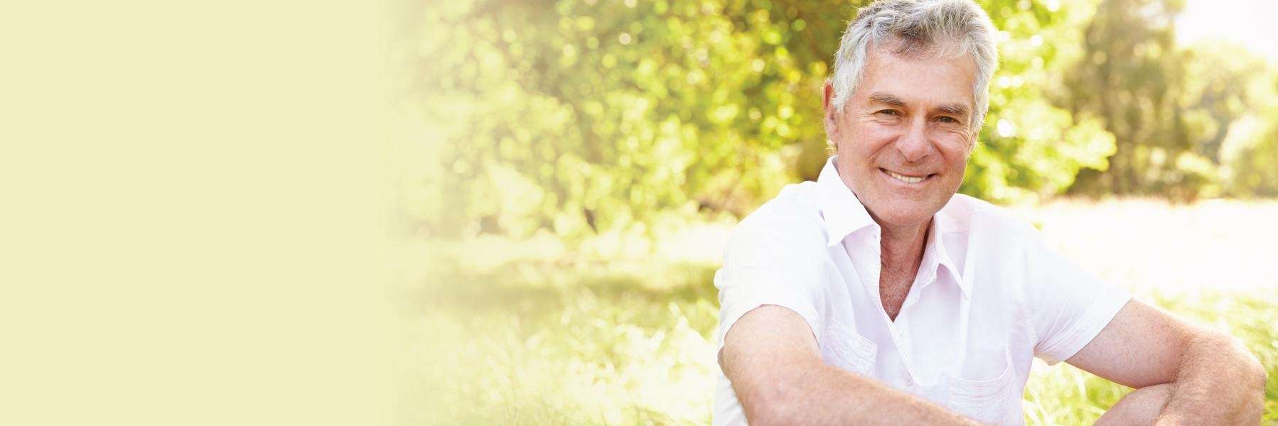 An older man sitting in the park | Dental Implants Corona, CA