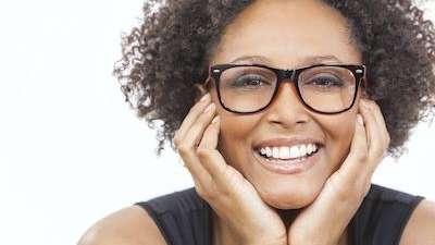 A smiling woman with glasses | cracked tooth Corona CA