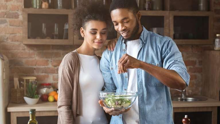 A couple making a salad