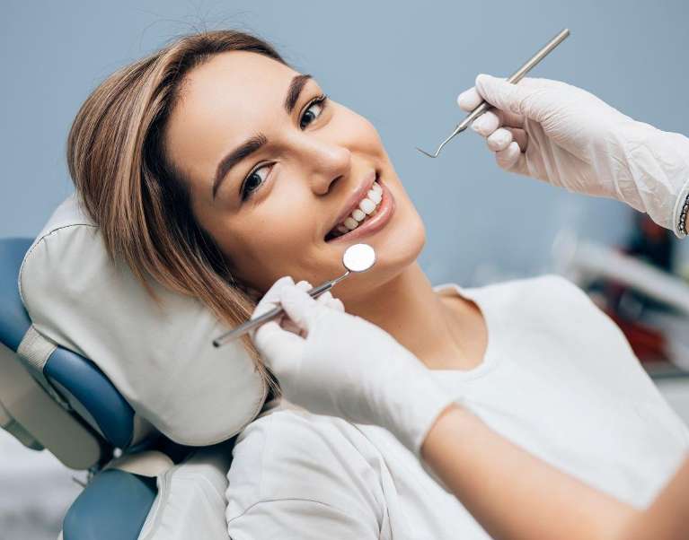 A smiling woman getting a dental exam | Dentist 92879